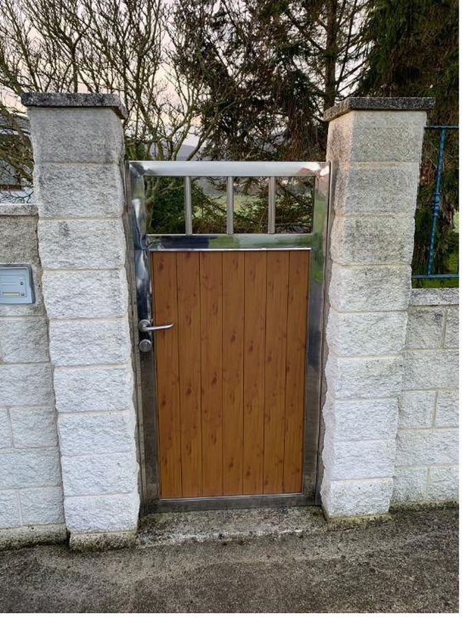 Puerta peatonal con madera y marco de acero inoxidable en A Coruña